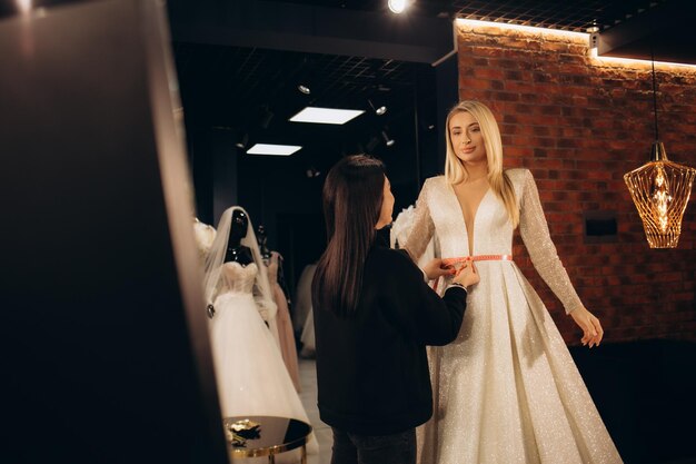 Photo attractive bride choosing a wedding dress in the store