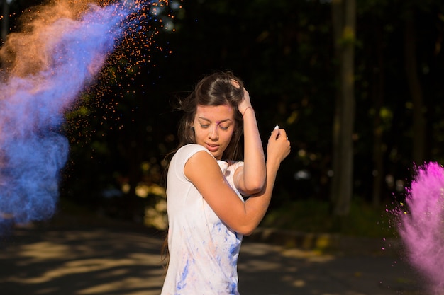 Photo attractive brunette asian woman with long hair playing with holi powder