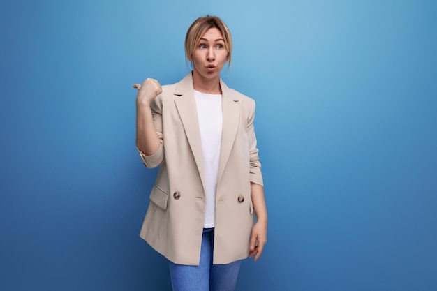 Attractive business woman in a beige jacket shows for having an idea with her finger on a studio