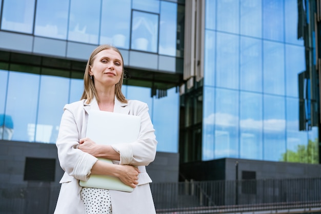 Attractive business woman business success charming beautiful woman is holding a laptop young woman ...