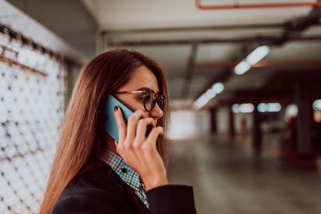 An attractive business woman in glasses using a smartphone. Selective Focus. Business Portrait. High quality photo