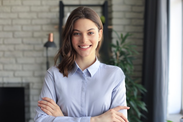 Attractive business woman smiling while standing in the office.