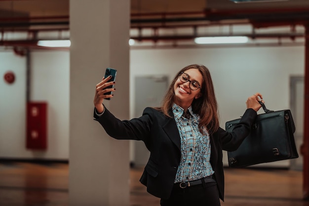 Attractive business woman in suit a briefcase taking a photo for social networks with a smartphone Selective focus