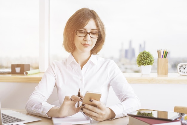 Attractive businesswoman using smartphone