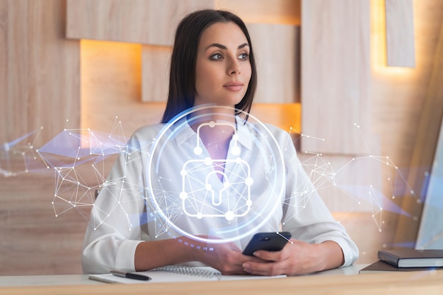 Attractive businesswoman in white shirt checking cyber security using smart phone to protect clients confidential information IT hologram lock icons over modern office background