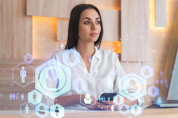 Attractive businesswoman in white shirt using smart phone to check new candidates for international business consulting HR social media icons over modern office background