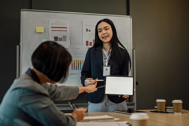 Attractive businesswoman with digital tablet giving a statistic presentation in boardroom