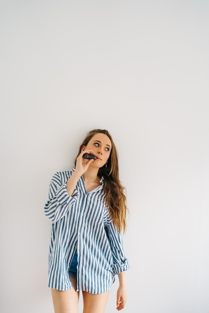 attractive caucasian female against white wall Close up of a female inhaling from electronic cigar