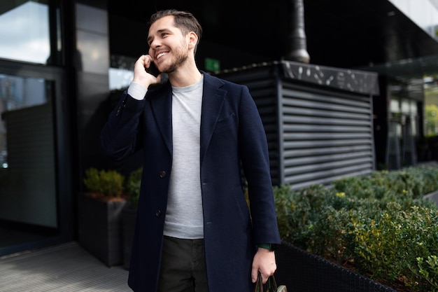 Attractive caucasian middle aged man talking on mobile phone outside