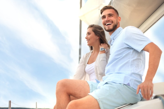 Attractive couple on a yacht enjoy bright sunny day on vacation.