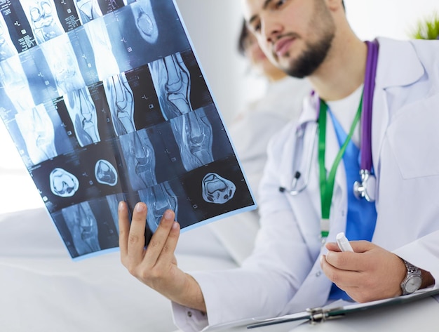 Attractive doctor examining an xray and smiling at the camera