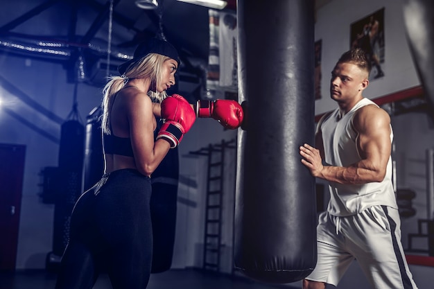 Attractive Female Boxer Training by hitting boxing punching bag