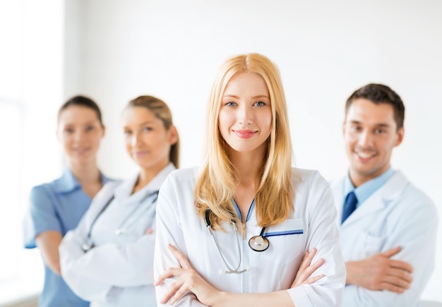 Photo attractive female doctor in front of medical group