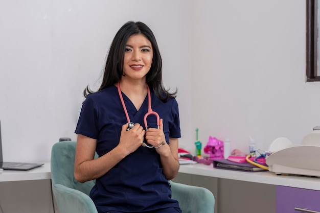 Attractive female health professional holding a stethoscope seated in her desk chair