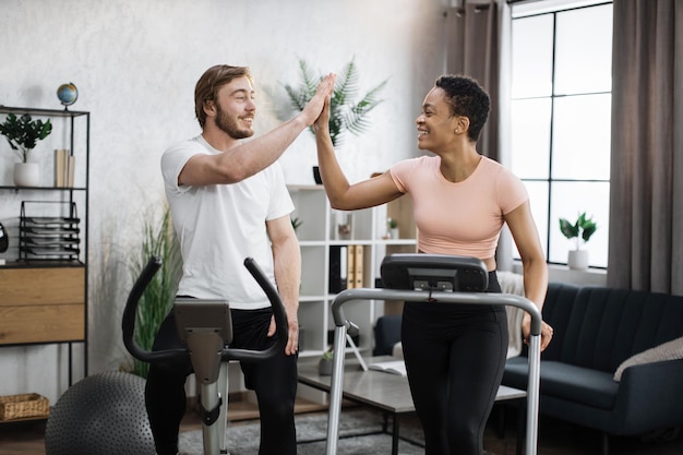 Attractive female and male working out on fitness at home