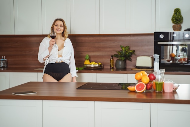 Attractive female person being in underwear in the kitchen, enjoying her lazy day