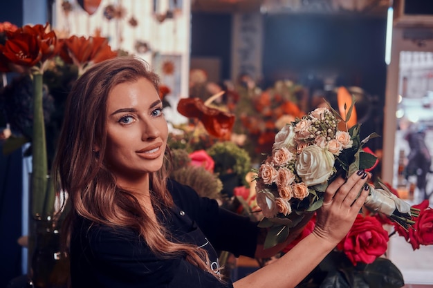 Attractive flower shop owner just created beautiful white rose bouquet.