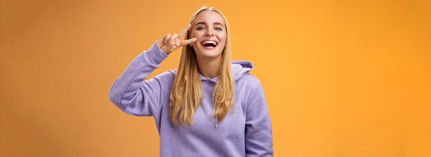 Attractive friendly carefree millennial blond girl in purple hoodie having fun friends laughing joyf