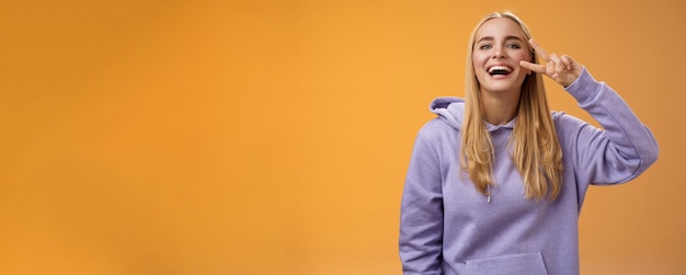 Attractive friendly carefree millennial blond girl in purple hoodie having fun friends laughing joyf