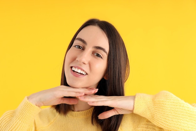 Attractive girl in sweater on yellow background