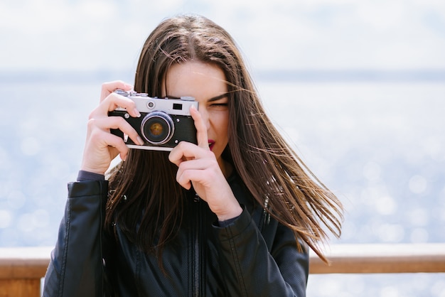 Attractive girl takes pictures with an old camera