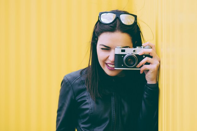 Attractive girl takes pictures with an old camera