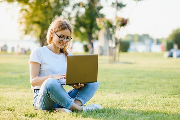 Attractive girl with a laptop in the park