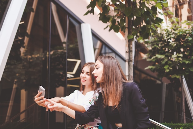 Attractive girls having fun with the smartphone