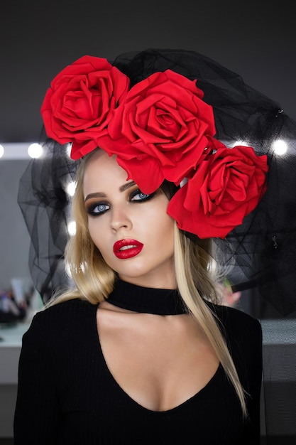 Attractive Goth female with bright makeup wearing amazing rose headgear and looking at camera