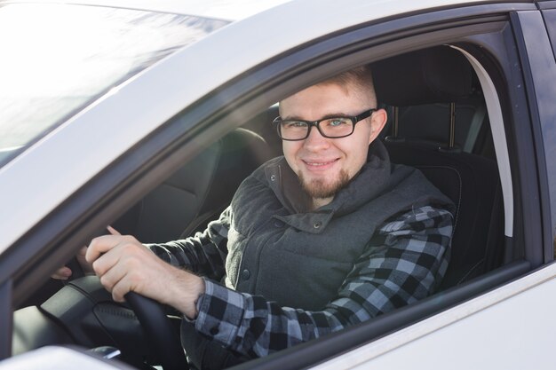 Attractive happy man in good white car