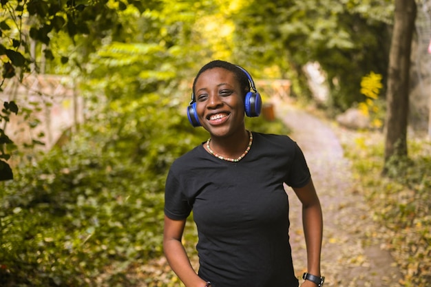 Attractive happy smiling young natural beauty short haired african black woman with blue headphones