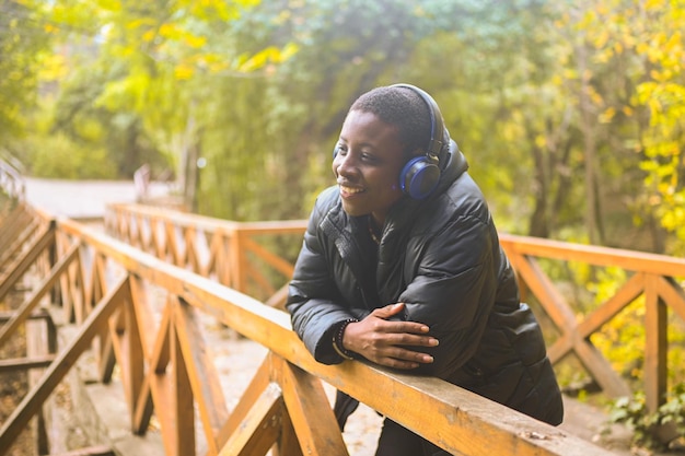 Attractive happy smiling young natural beauty short haired african black woman with blue headphones