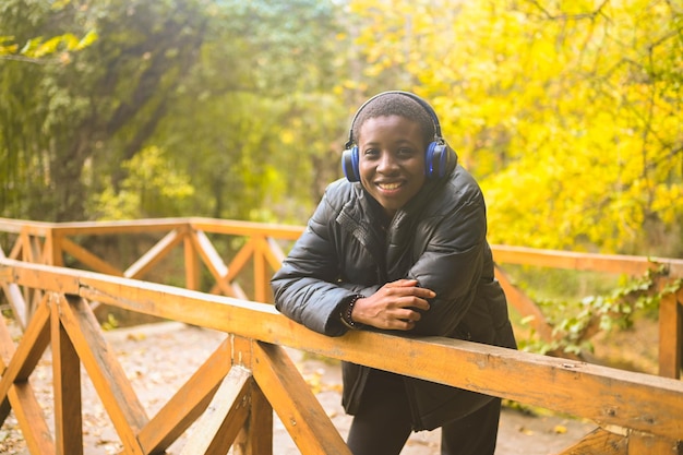 Attractive happy smiling young natural beauty short haired african black woman with blue headphones