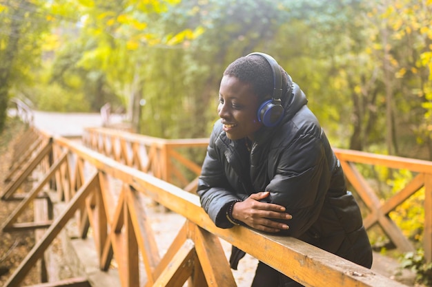 Attractive happy smiling young natural beauty short haired african black woman with blue headphones