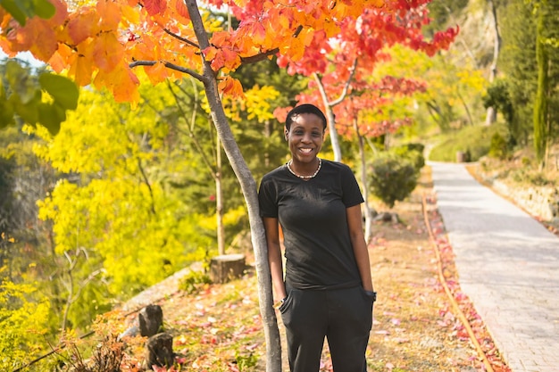 Attractive happy smiling young natural beauty short haired african woman wearing total black walking