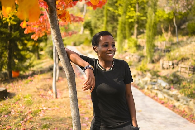 Attractive happy smiling young natural beauty short haired african woman wearing total black walking