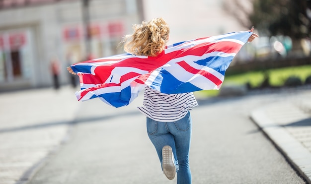 Attractive happy young girl with the flag of the Great Britain.