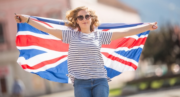 Attractive happy young girl with the flag of the Great Britain.