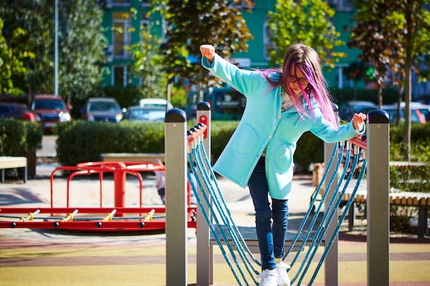 Attractive little girl on outdoor playground equipment.