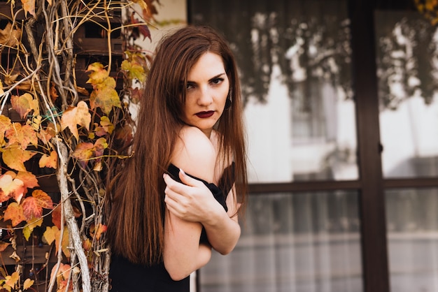 Attractive luxury woman with long hair posing in her garden, enjoying a rich life