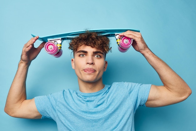 Attractive man blue skateboard in hand isolated background