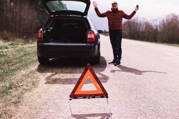 Attractive man having trouble with his car on the roadGuy having trouble on the countryside