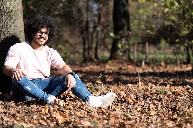 Attractive Man Resting in Autumn Forest