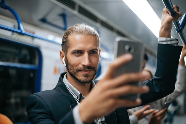 Attractive man using his smartphone in subway train