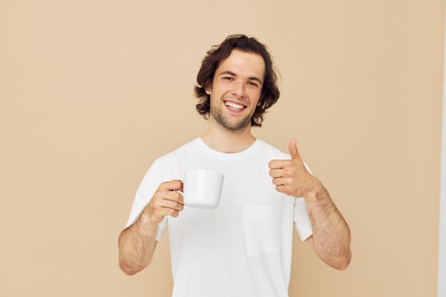 Attractive man with a white mug in his hands emotions posing isolated background