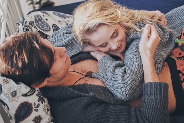 Attractive man and woman in the bedroom together cuddling cute