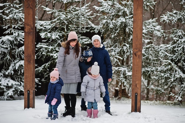 Attractive mother with her four kids in winter day