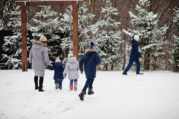 Attractive mother with her four kids in winter day