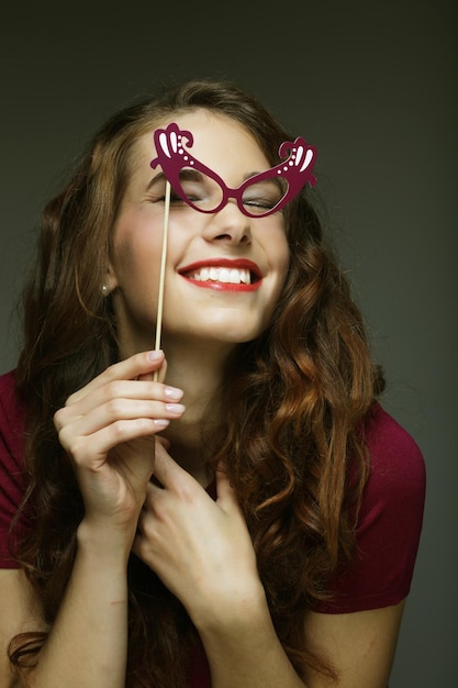 Attractive playful young woman with false glasses ready for party