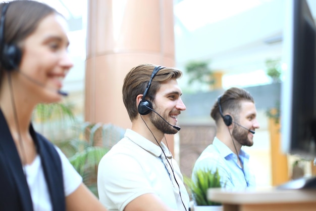 Attractive positive young businesspeople and colleagues in a call center office.